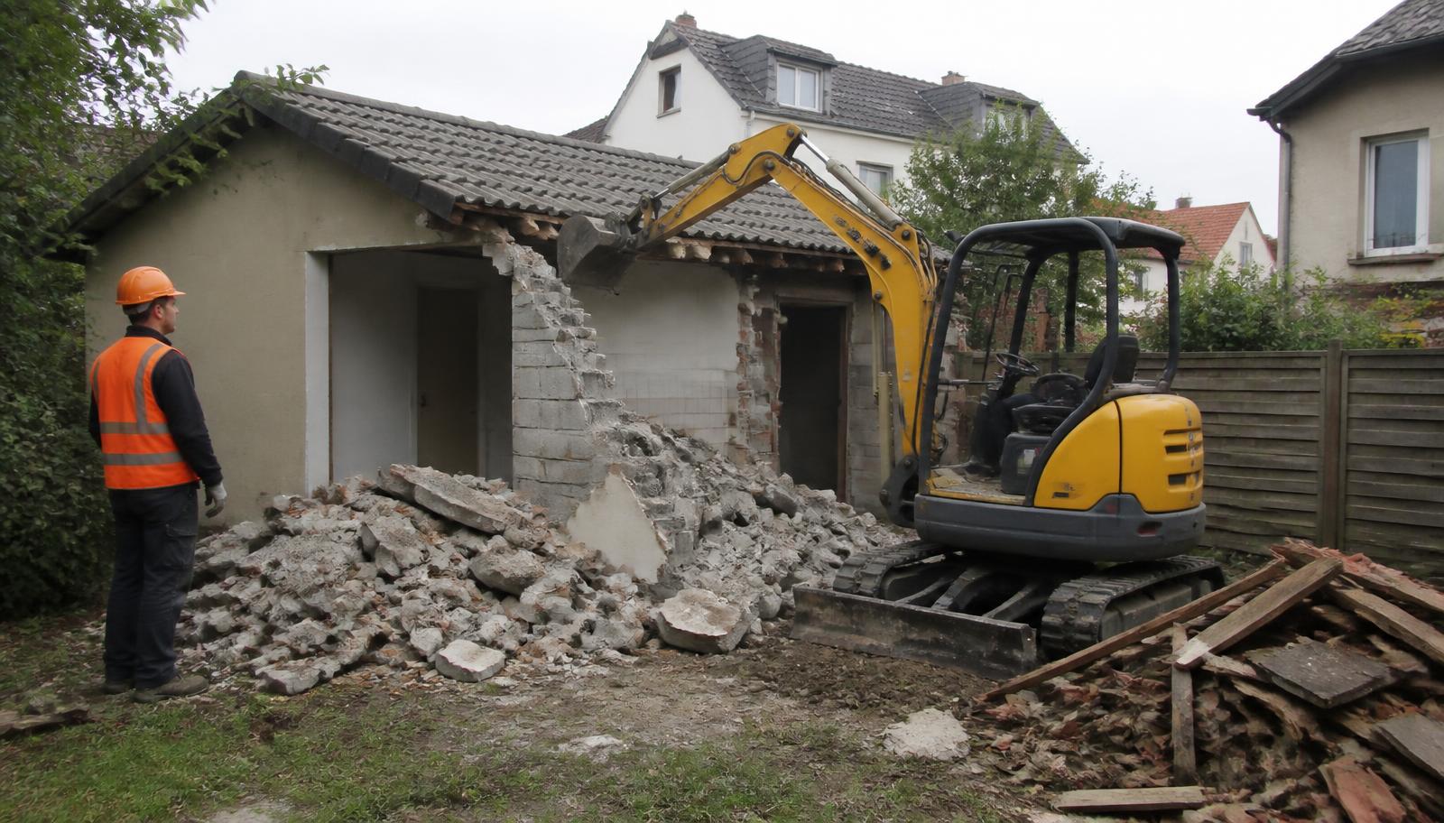 Abriss einer alten Garage mit Minibagger im Hinterhof